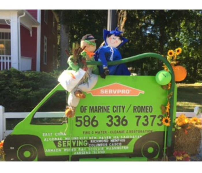 Halloween display with a SERVPRO cardboard truck and scarecrows