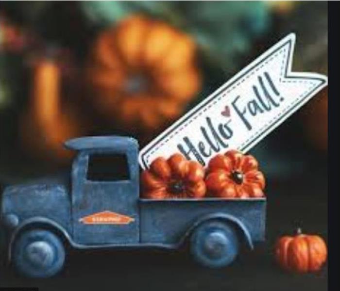 Toy truck carrying a pumpkin and a fall sign